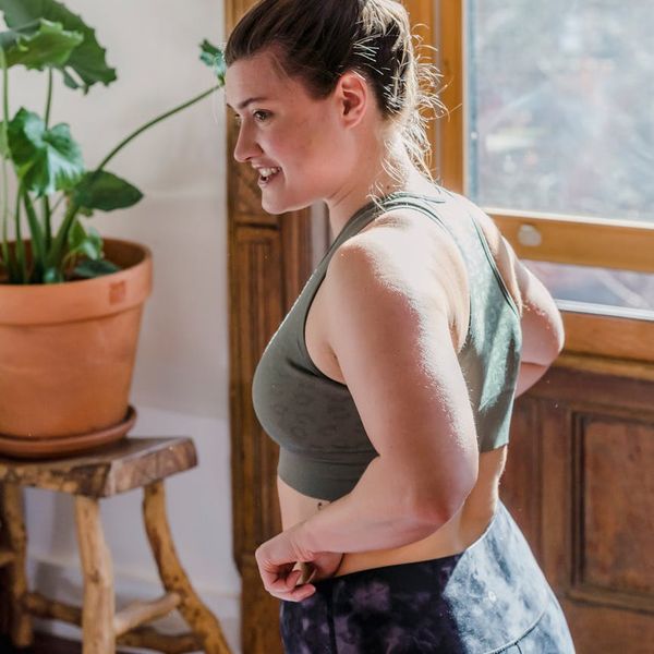 Smiling woman stretching outdoors, feeling energized and happy.